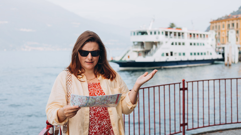 Confused woman on cruise port holding a map