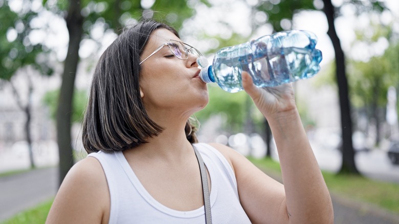 Woman drinking water in a park