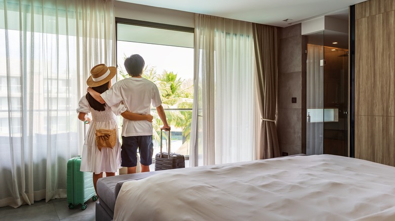 Couple looking out of window in hotel room