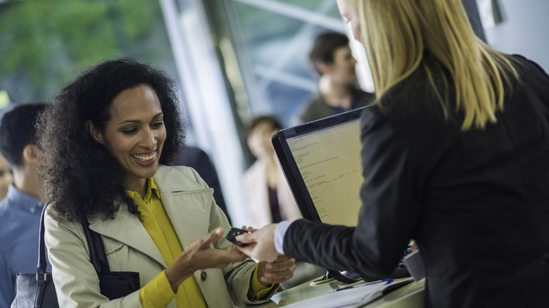 Woman renting a car at a rental counter