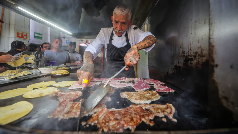 Chef grilling beef for tacos at Michelin-starred taco stand