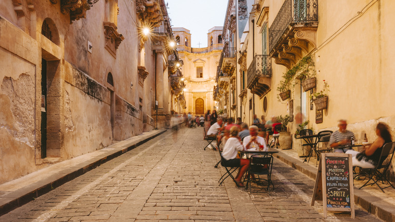 Outdoor dining in a narrow street in Noto