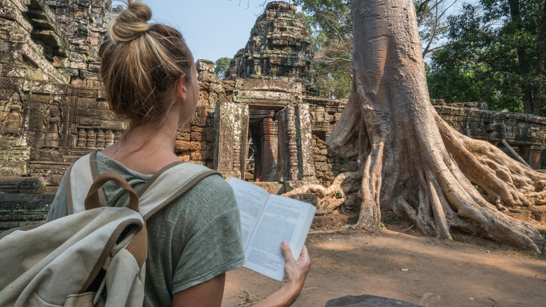 Traveler in Cambodia with a book