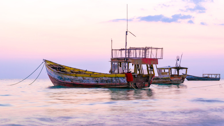 A boat in the sea off the coast of Bluefields, Jamaica, at sunset