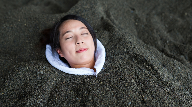 A woman enjoys a hot volcanic sand bath