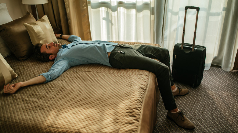 Man sleeping on a hotel bed after just arriving