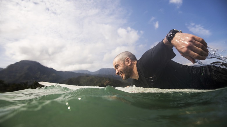 A surfer paddles out on his surfboard to catch a wave