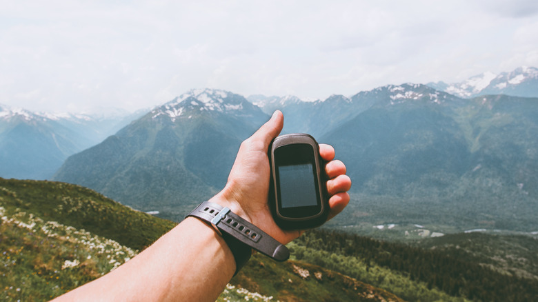 holding GPS tracker in mountains
