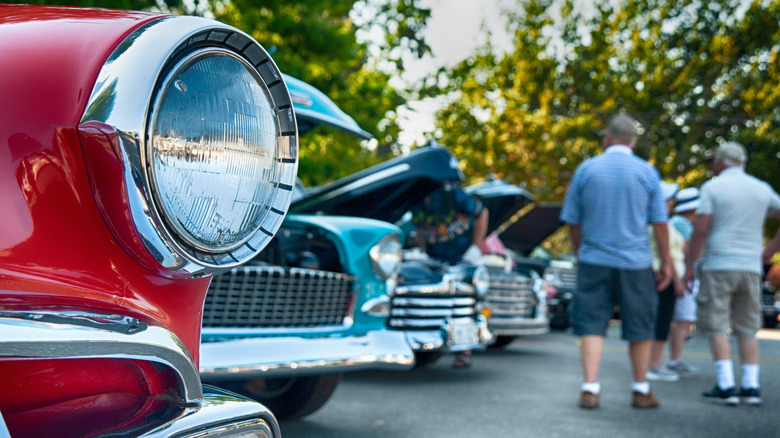 People walking through a vintage car show