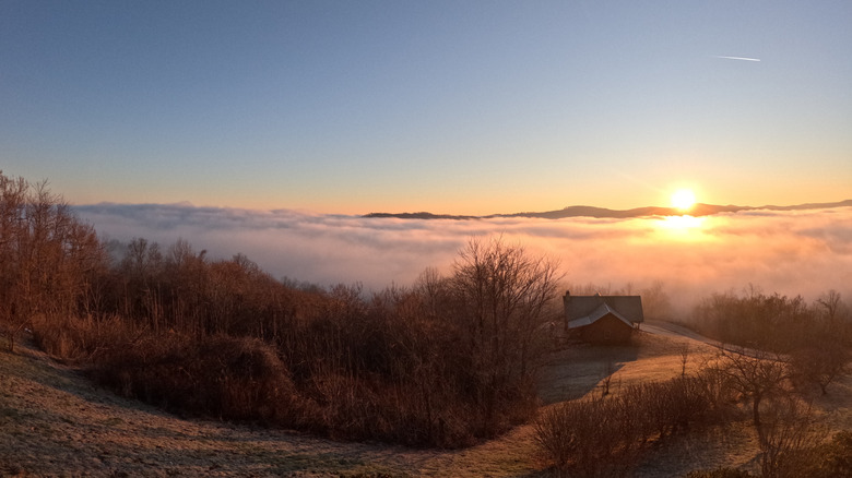 Sunrise at Dale Hollow Lake with a lake house in the distance