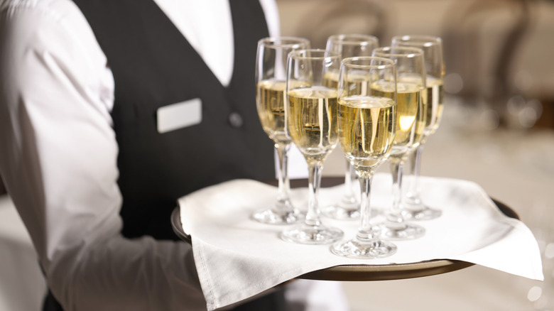 A butler holding a tray of champagne