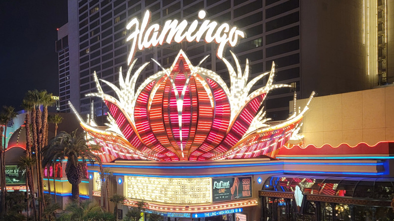 The front entrance of the Flamingo Hotel and Casino with bright colorful lights in the front