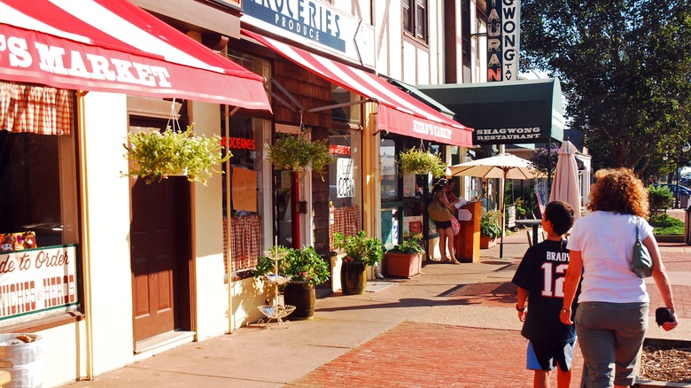 Woman and boy stroll by shops in Montauk, New York