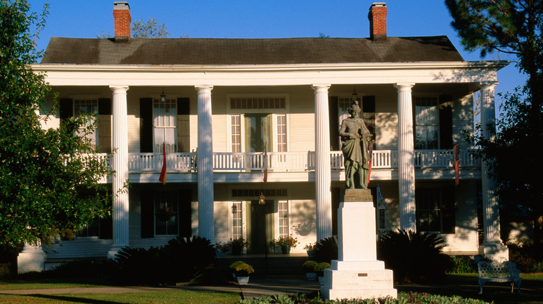 A double gallery house with a statue in front in St. Martinville, Louisiana