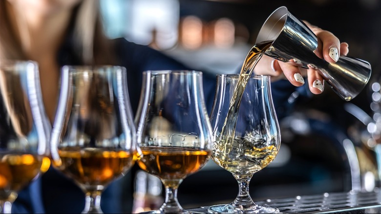 a bartender pouring bourbon