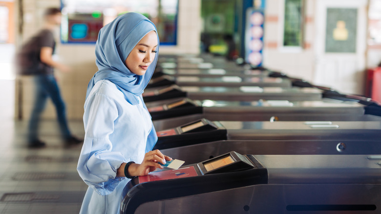 A woman scanning her metro card in Kuala Lumpur