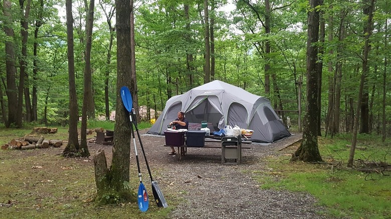 A man outside of a grey tent at Rocky Gap State Park