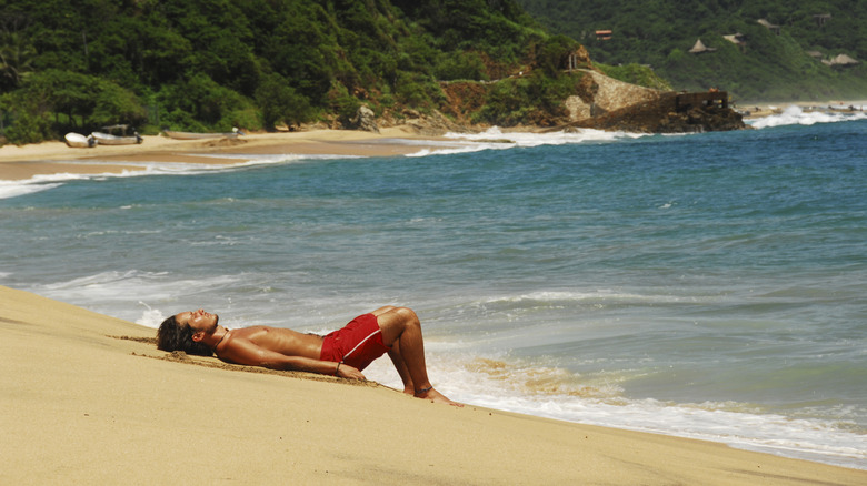 Man lying on Mazunte beach in Mexico