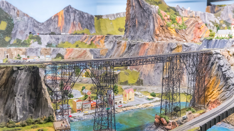 model train bridge across cliffs with a village and river below at NorthlandZ in Flemington, New Jersey