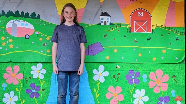 Girl taking photo with a Mural in Mentone, Alabama