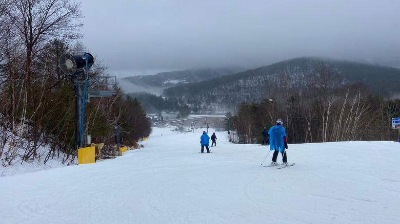 People skiing at Gunstock Mountain on a cloudy day in New Hampshire