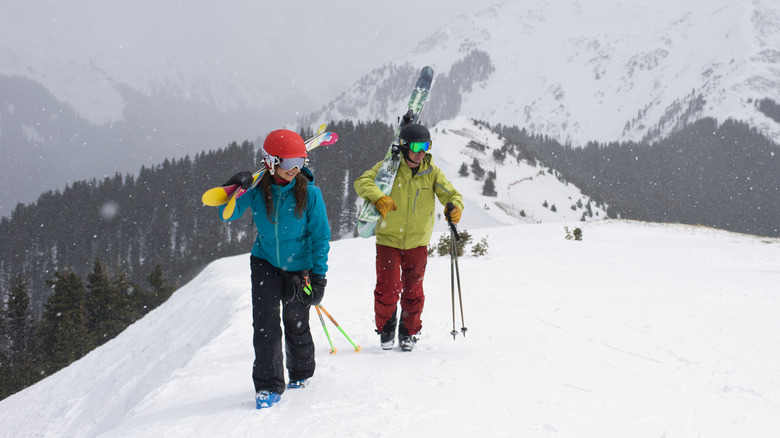 Two skiers on a snowy ridge in Taos, New Mexico