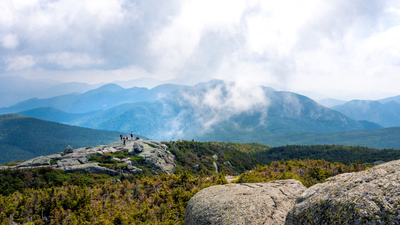 Hikers on towering mountain summit