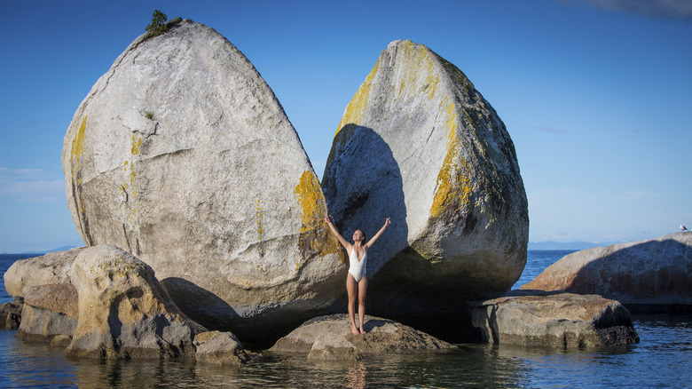 Visitor standing in front of Split Apple Rock in Abel Tasman National Park