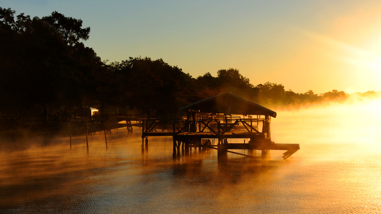 Lake Chicot at sunrise with a wooden structure in the center