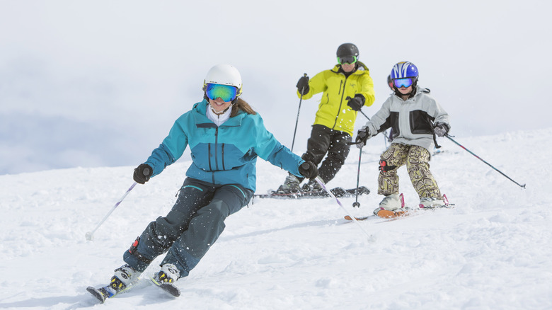 Family skiing down a slope in the snow