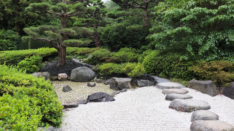 A traditional Japanese Garden with a sand zen garden a lush greenery