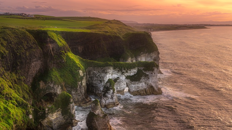 Beautiful, white limestone cliffs seen from the Magheracross Viewpoint in Bushmills, Northern Ireland, along the Causeway Coast, during a dramatic sunset