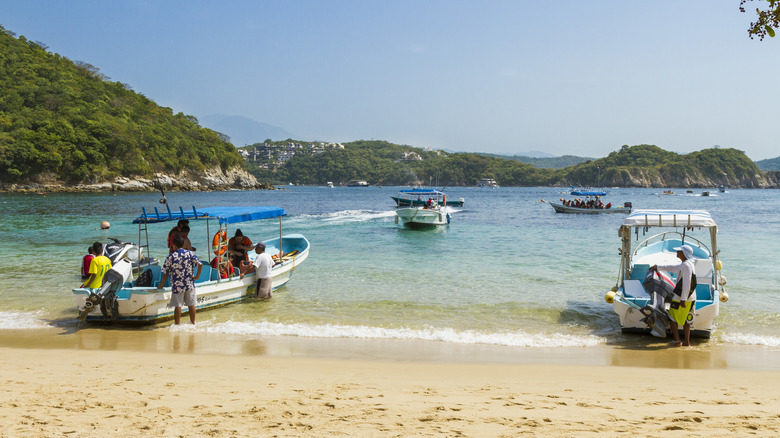 Boats on the sand and water at La Entrega Beach