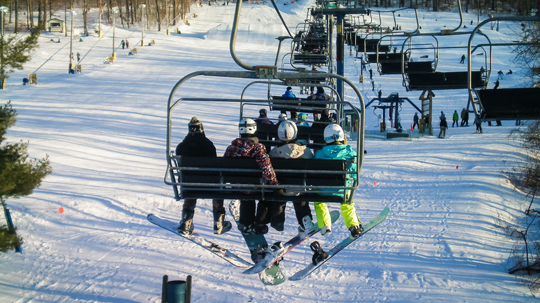 Four snowboarders sitting on a lift at Snowshoe Resort