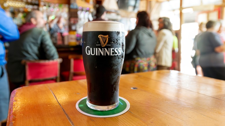 A glass of Guinness on a table inside a pub