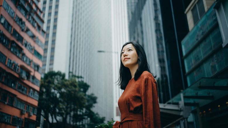 Woman among tall city buildings