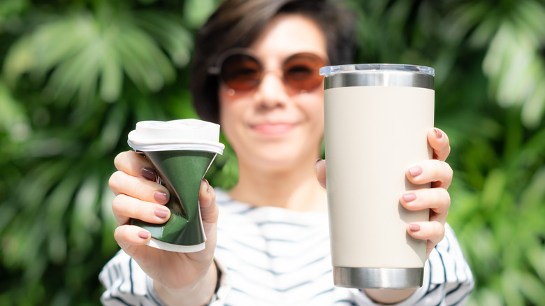 Woman holding cup and reusable tumbler