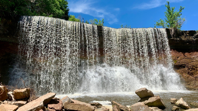 A daytime view of Cowley County Waterfall with trees in the background