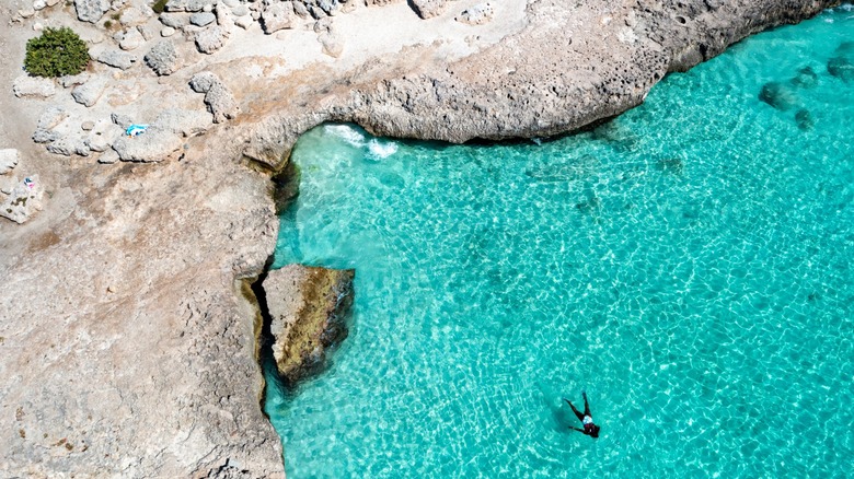 An aerial view of the rocky steps leading into the sea at Tres Trapi Beach