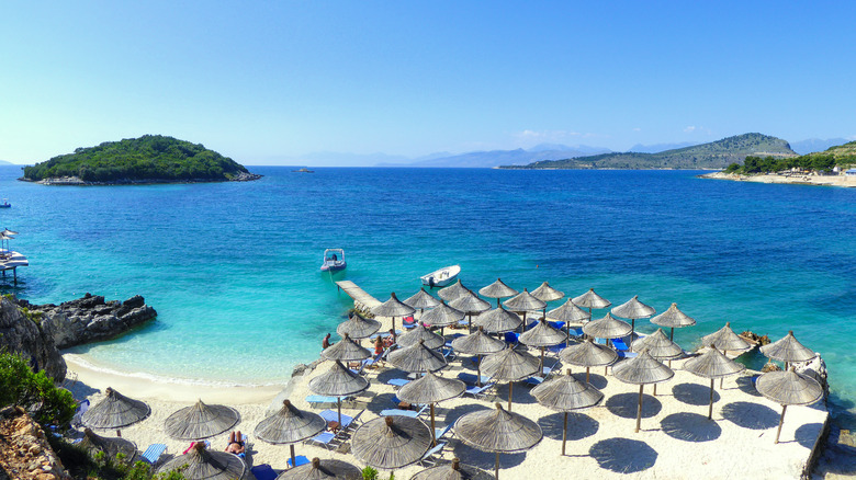 Umbrellas and blue waters at a beach in Ksamil, Albania