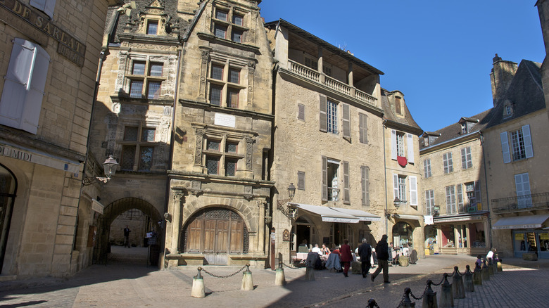 people walking in front of a historical building in Sarlat, France