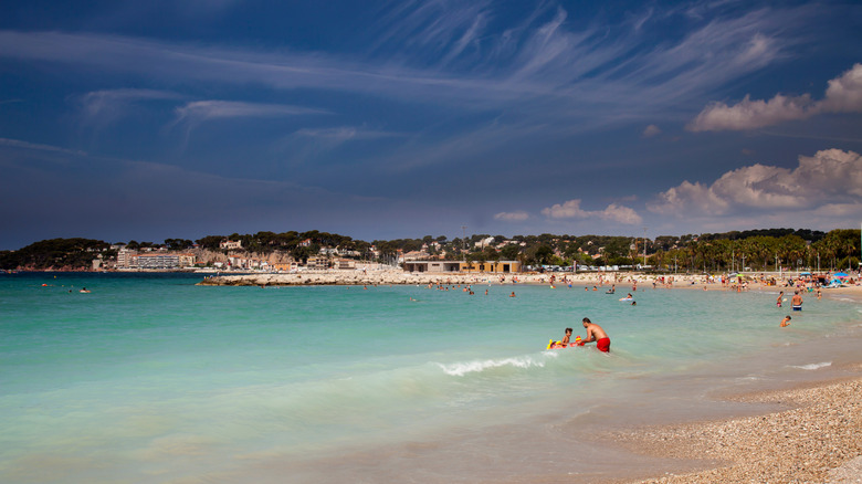 Bathers in the surf at large sandy beach at Sanary