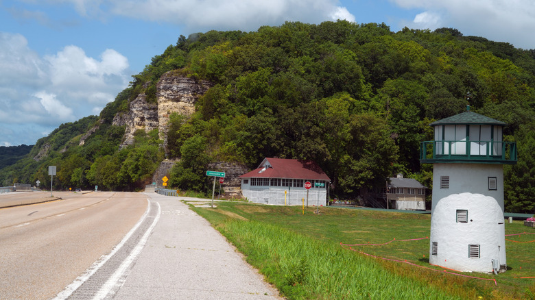 Great River Road near Elsah, Illinois with small buildings and a green mountain