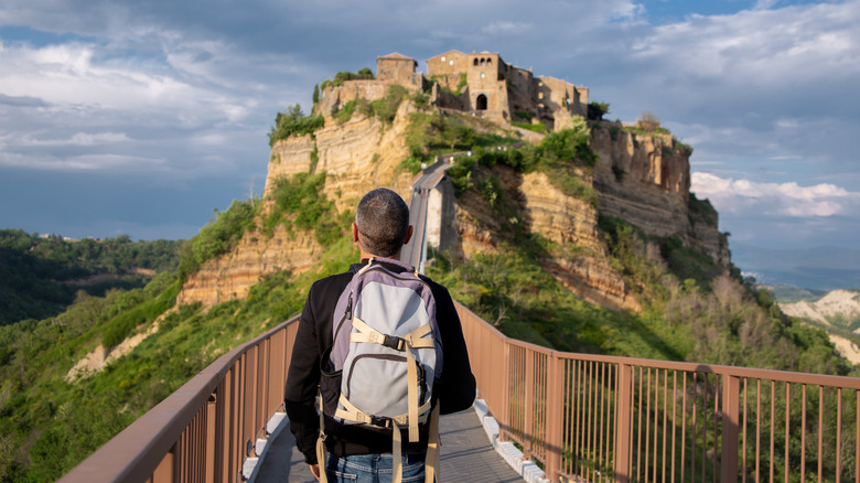 A person crossing the bridge into Civita di Bagnoregio, Italy