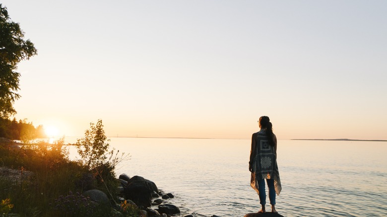 woman standing on rugged beach