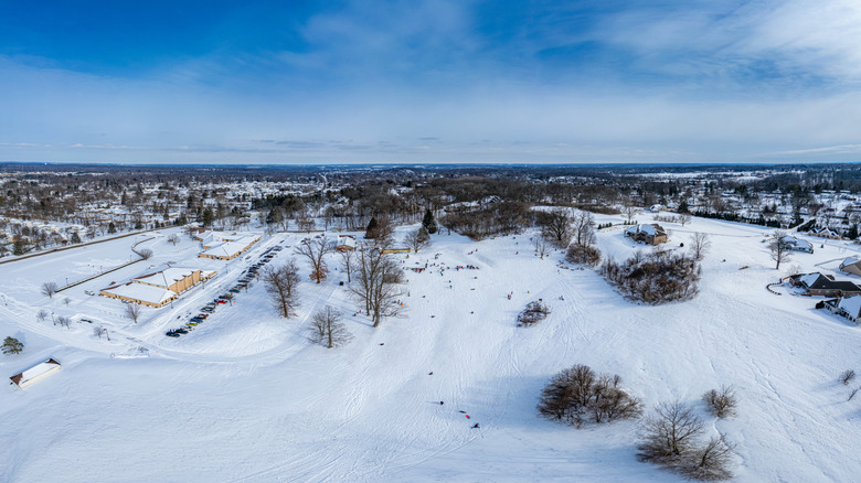 Aerial view of snowy park with people sledding in Ohio