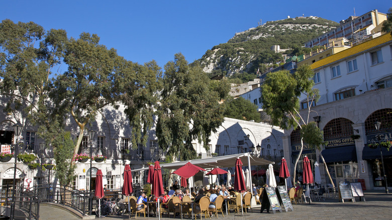 Restaurant with outdoor terrace at the foot of large rock surrounded by trees