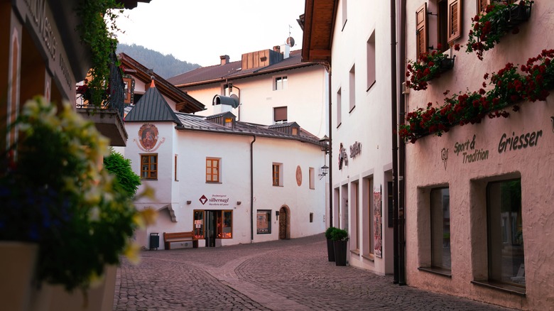 cobblestone street white buildings Castelrotto