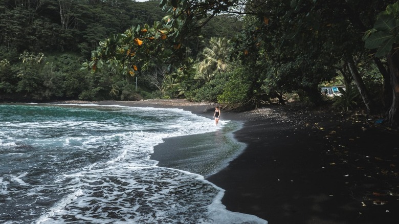 Women walking along Papenoo Beach 