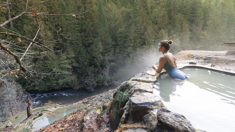 Woman soaking in a forest hot spring